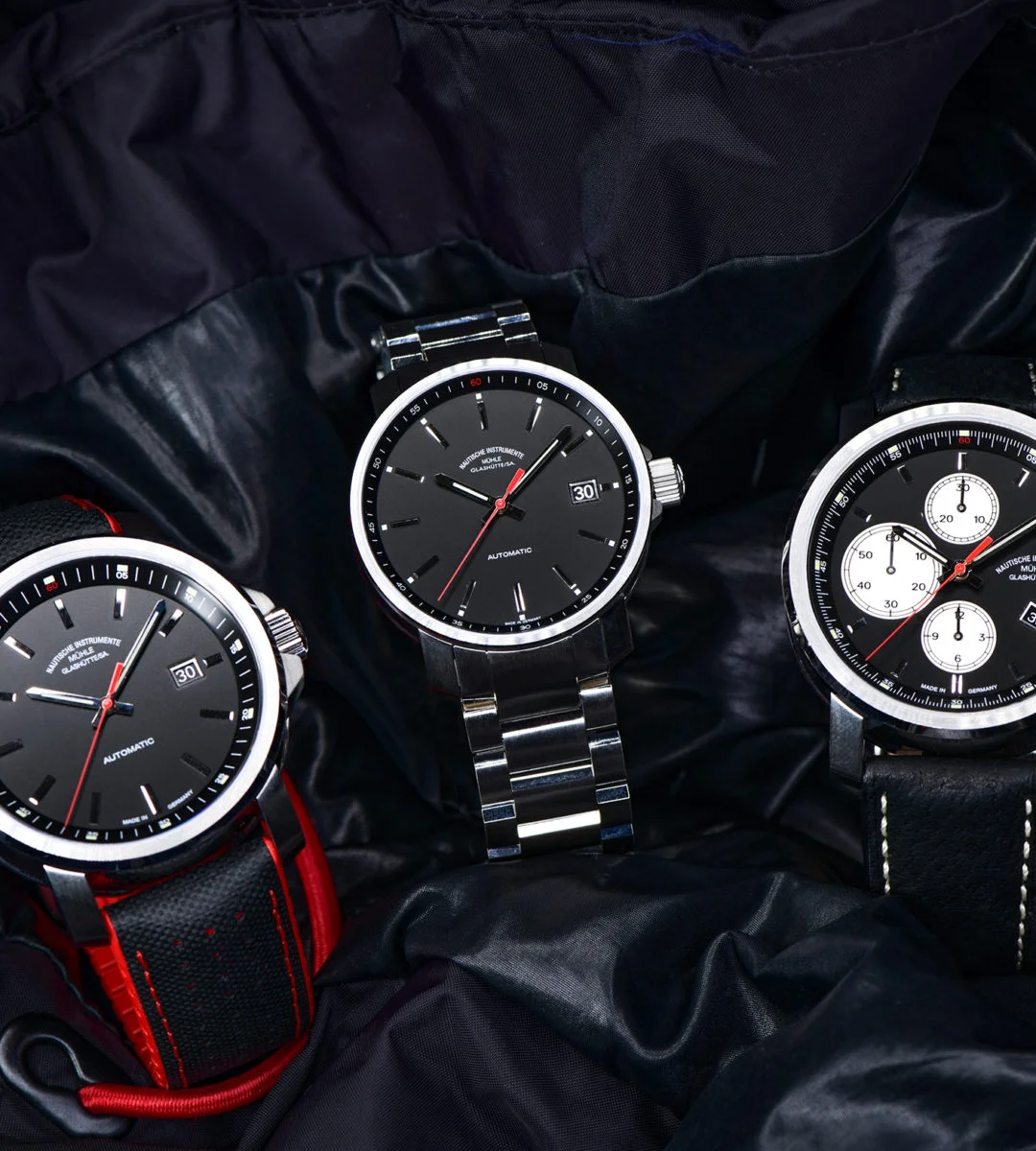 Drei Armbanduhren mit schwarzen Zifferblättern (v.l.n.r.: 29er Big, 29er, 29er Chronograph) an dunklen Armbändern stehen auf einer schwarzen Lederjacke.