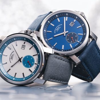 The 29er Big Small Seconds with a stone-white dial and grey strap and the 29er Big Small Seconds with a blue dial and strap are stacked on top of each other on the side.