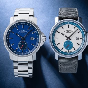 The 29er Big Small Seconds with blue dial and metal bracelet and the 29er Big Small Seconds with white-petroleum dial and grey strap lie side by side on a blue background