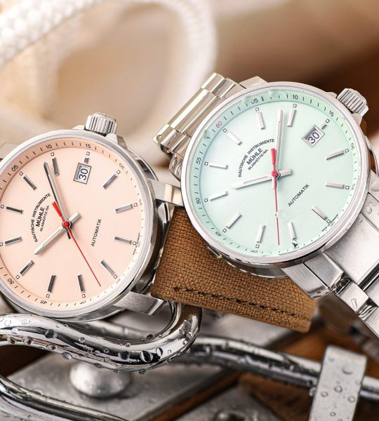 Zwei Armbanduhren (29er mit apricot-farbenem und mintfarbenem Zifferblatt) liegen auf Metallschlaufen und Seilen.