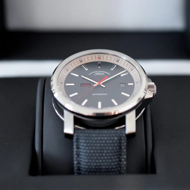 Armbanduhr 29er Tag/Datum am blauen Canvasband steckt auf dem Uhrenkissen im Etui.