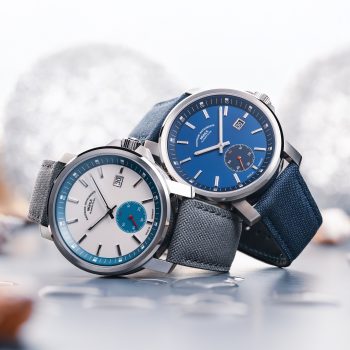 The 29er Big Small Seconds with a stone-white dial and grey strap and the 29er Big Small Seconds with a blue dial and strap are stacked on top of each other on the side.