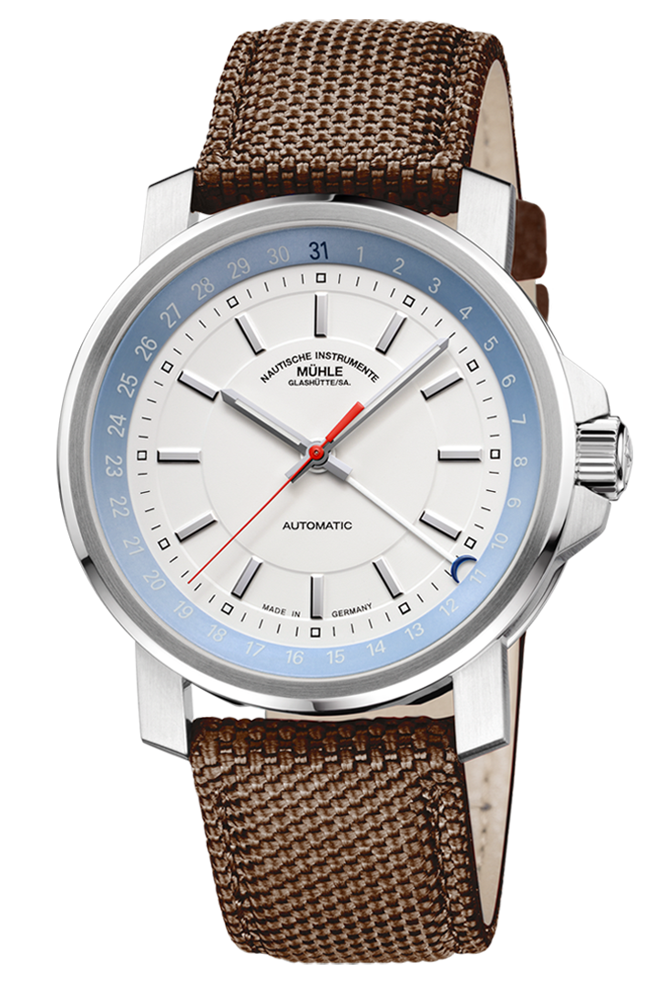 29er Zeigerdatum: Frontalansicht einer Armbanduhr mit einem weißeren Zifferblatt und hellblauem Rehaut in einem silbernen Gehäuse am braunen Canvasband.