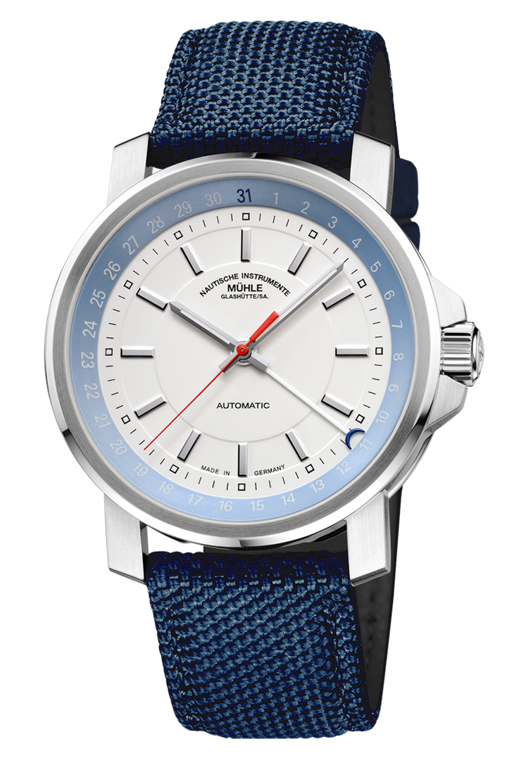 29er Zeigerdatum: Frontalansicht einer Armbanduhr mit einem weißeren Zifferblatt und hellblauem Rehaut in einem silbernen Gehäuse am blauen Canvasband.