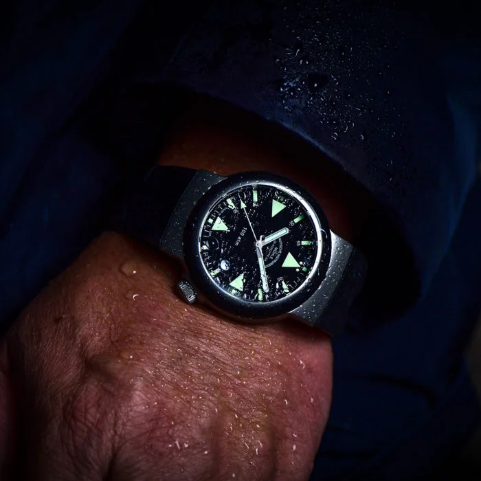 Wristshot des S.A.R. Rescue-Timers, einer Armbanduhr mit schwarzem Zifferblatt, grünlichen Indizes, schwarzer Lünette und matt-silbernem Gehäuse.