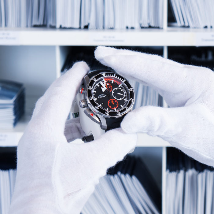 Zwei Hände mit weißen Handschuhen halten einen S.A.R. Flieger-Chronographen.