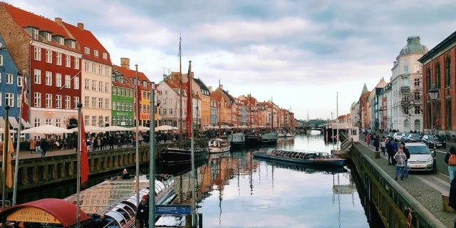 Kopenhagener Kanal, in dem sich der wolkige Himmel spiegelt. Am Rand bunte Häuser.