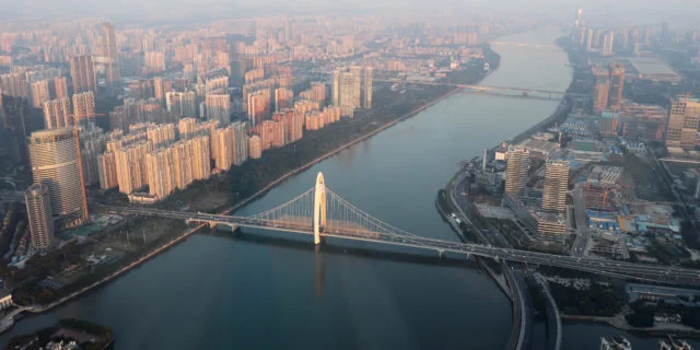 Luftaufnahme von Guangzhou. In der Mitte fließt ein Fluß, darüber verläuft eine Brücke.