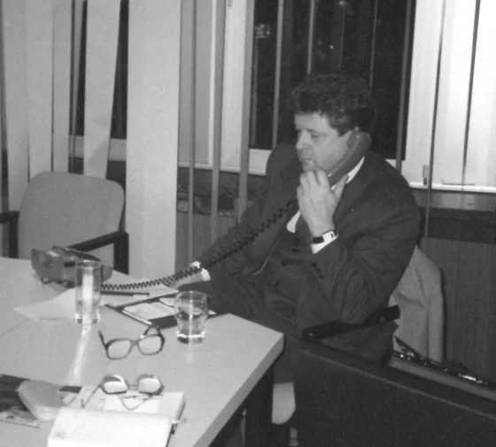 Historische Schwarz-Weiß-Aufnahme von Hans-Jürgen Mühle telefoniert an einem Tisch sitzend