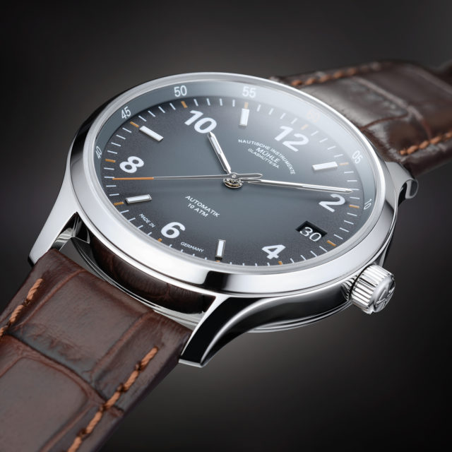 Armbanduhr Lunova Datum am braunen Krokolederband vor schwarz-grauem Hintergrund.