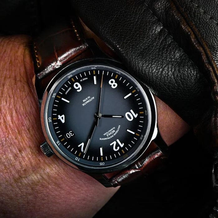 Armbanduhr Lunova Datum am braunen Krokolederband wird am Handgelenk getragen.
