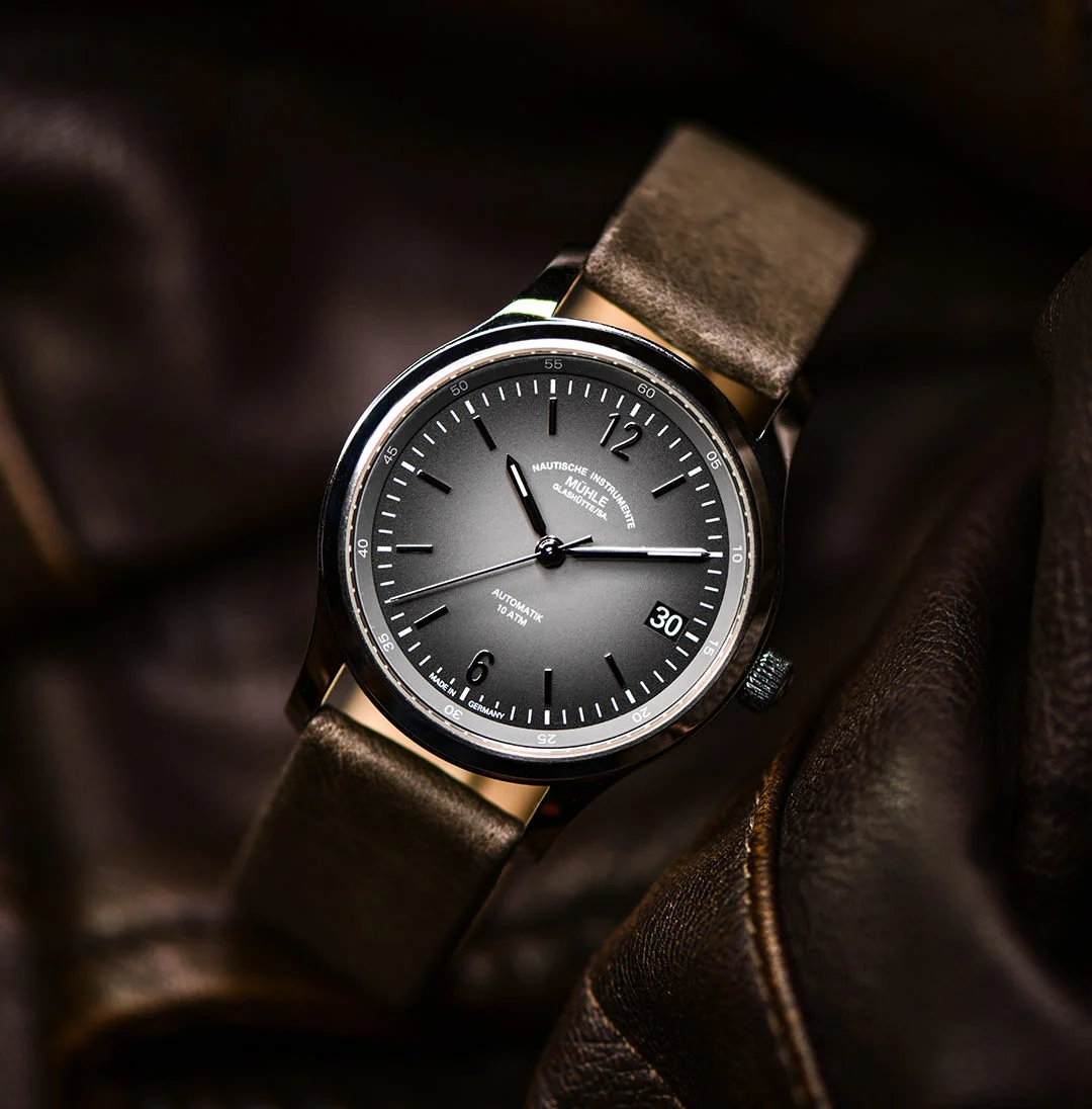 Armbanduhr Lunova Lady am grauen Lederband steht auf einer braunen Lederjacke.
