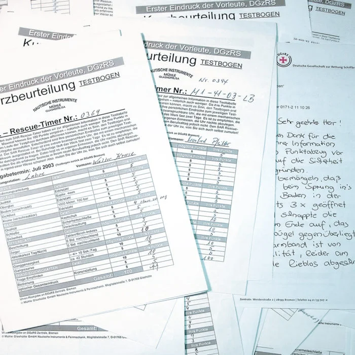 Mehrere Bögen weißes Papier mit schwarzer Schrift liegen übereinander.