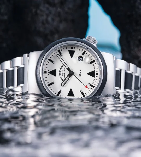 S.A.R. Rescue-Timer Lumen am Metall-Kautschukband liegt seitlich im seichten Wasser.