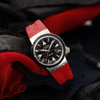 Frontalansicht des S.A.R. Rescue-Timer am roten Kautschukband vor roter Rettungsjacke.