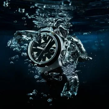 S.A.R. Rescue-Timer mit schwarzem Kautschukband im Wasser mit aufsteigenden Luftblasen