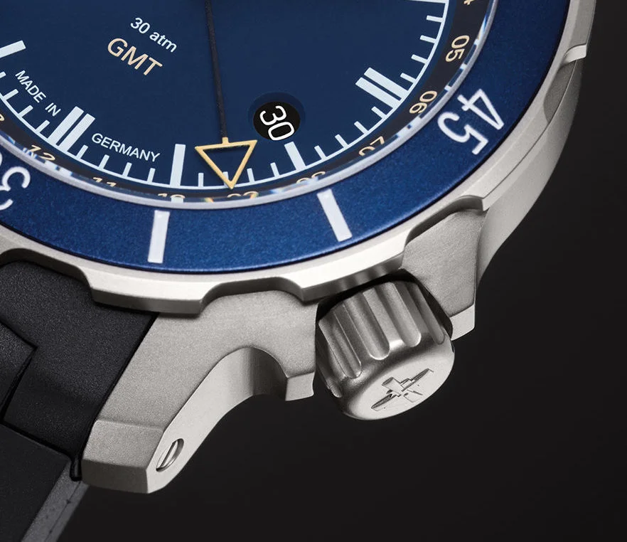 Markoaufnahme der Krone und Lünette der Sebataillion GMT, einer Armbanduhr mit blauem Zifferblatt, blauer Lünette und matt-silbernem Gehäuse.