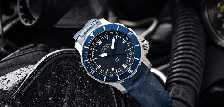 Seebataillon GMT mit blauem Kautschukband liegt leicht schräg auf schwarzer Taucherbrille und Schnorchel.