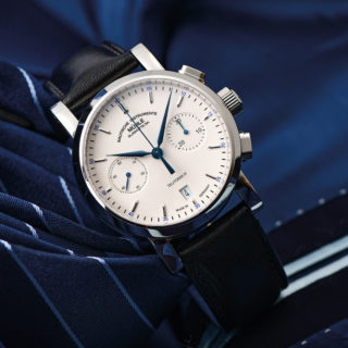 Armbanduhr Teutonia IV Chronograph am schwarzen Lederband steht leicht schräg auf blauen Krawatten.