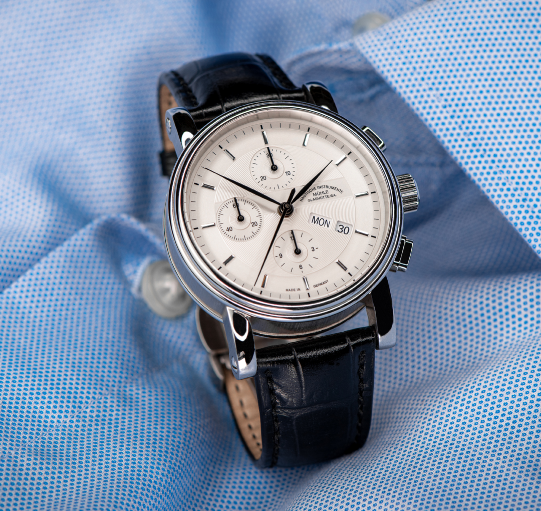 Armbanduhr Teutonia II Chronograph am schwarzen Lederband steht auf einem hellblauen Herrenhemd.