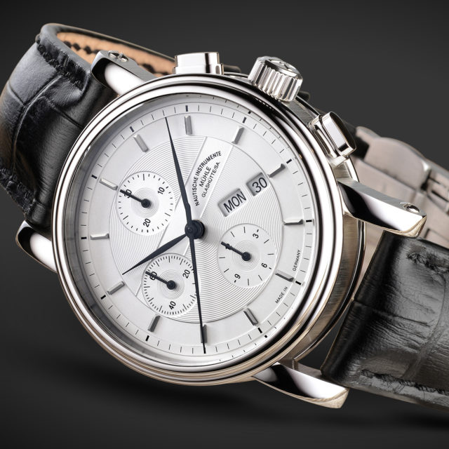 Armbanduhr Teutonia II Chronograph am schwarzen Lederband liegt seitlich auf einer schwarzen Oberfläche.