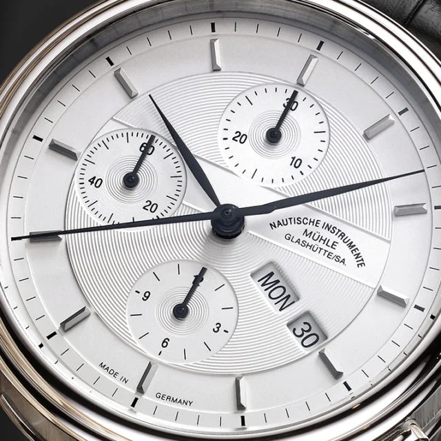 Weißes Zifferblatt des Teutonia II Chronograph mit schwarzen Zeigern im silbernen Gehäuse.