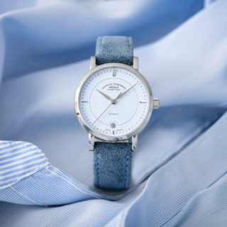 Armbanduhr Teutonia IV Lady mit pastellblauem Zifferblatt am blauen Veloursband steht auf einer hellblauen Damenbluse.