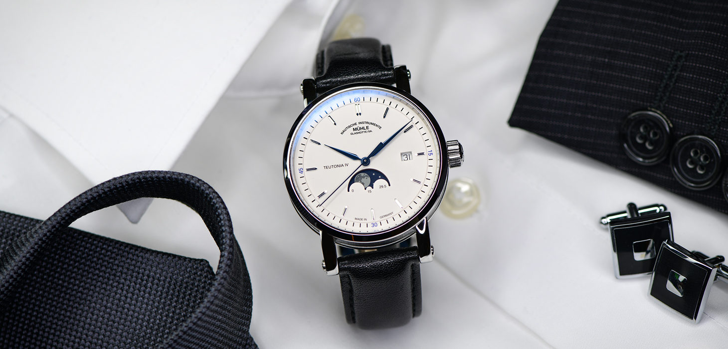 Armbanduhr Teutonia IV Mondphase am schwarzen Lederband steht auf einem weißen Herrenhemd.