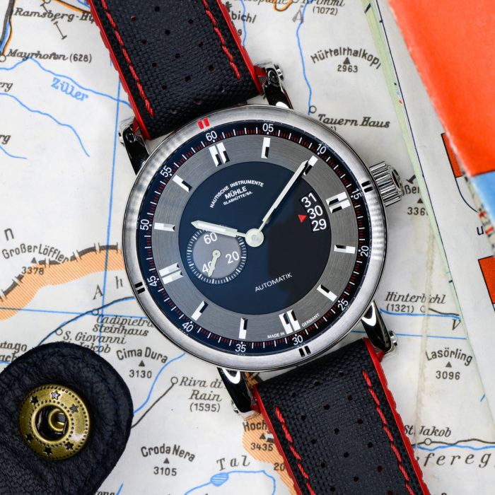 Armbanduhr Teutonia Sport II am schwarz-roten Leder-Kautschukband liegt auf einer Landkarte.