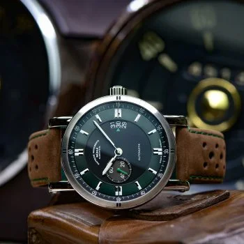 Armbanduhr Teutonia Sport II "Racing Green" am braunen Lederband liegt seitlich auf einem Stück Leder.