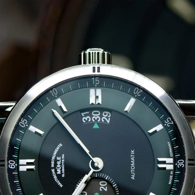 Teutonia Sport II "Racing Green" seitlich liegend. Fokus auf den rechten Gehäuserand und die verschraubte Krone.