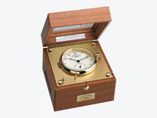 Quarz-Marinechronometer: Nautisches Zeitmessinstrument mit weißem Zifferblatt und Messingplatine in einer Holzbox