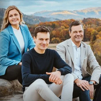 Fanny, Dustin und Thilo Mühle sitzen auf einem Felsen, im Hintergrund ein Wald der Sächsischen Schweiz
