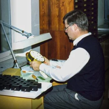 Hans-Jürgen Mühle an einem Tisch bei der Kontrolle einer Schiffsuhr