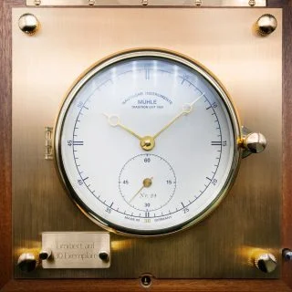 Frontalansicht des weißen Zifferblatts des Quarz-Marinechronometer Edition 1994 auf Messingplakette.