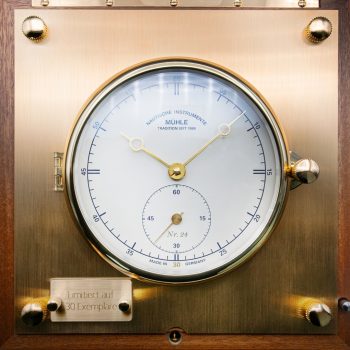 Frontalansicht des weißen Zifferblatts des Quarz-Marinechronometer Edition 1994 auf Messingplakette.