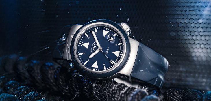 Armbanduhr "S.A.R. Rescue-Timer" mit blauem Zifferblatt und blauem Kautschukband liegt seitlich auf Seilen.