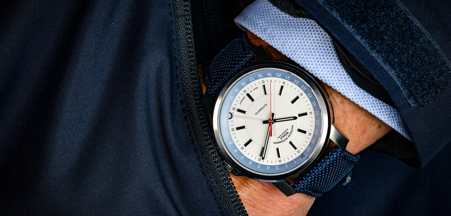 Armbanduhr "29er Zeigerdatum" mit blauem Canvasband wird am Handgelenk getragen.
